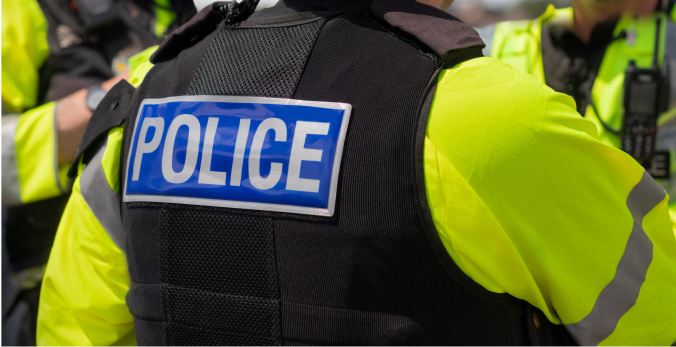 A police officer wearing a vest that says Police on the back